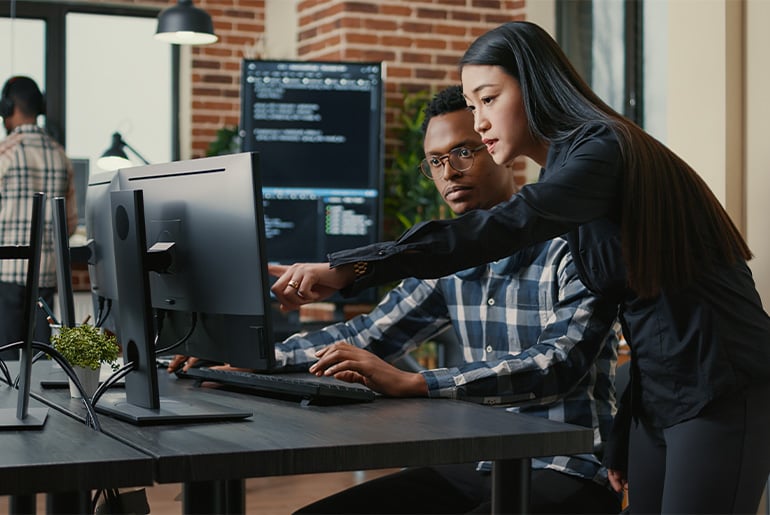 Mann und Frau zeigen auf den Computer