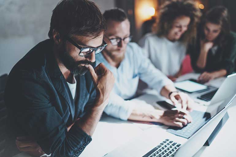 Gruppe von Personen, die an ihren Laptops arbeiten